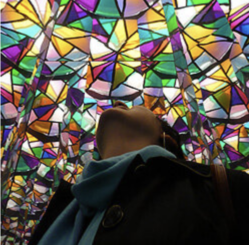 Alexandra looking away from the camera, up at a stained glass ceiling
